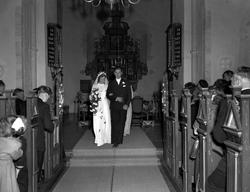 Brudefoto fra kirken, med brudeparet foran alteret. Det er u