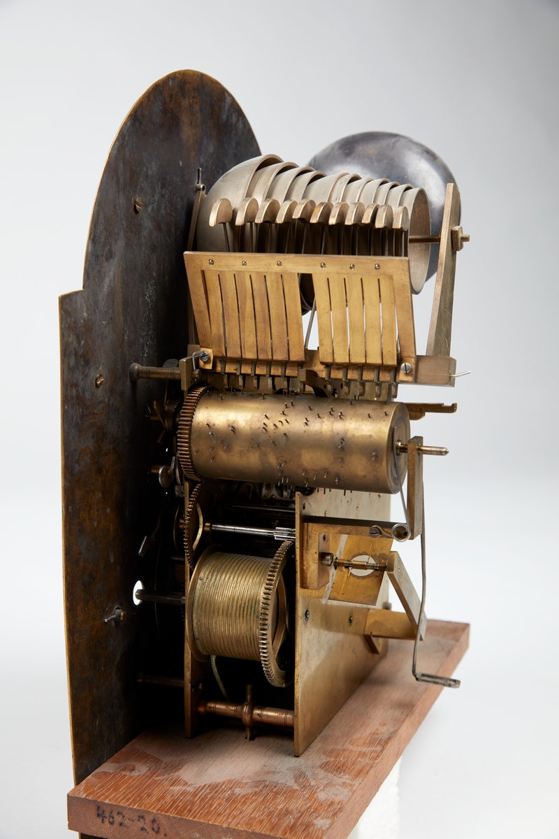 Rødmalt gulvur med forsiringer i form av nettverk, sped, stilisert akantus og rocaille. Urverket har sekund-, minutt- og datoviser og er forsynt med spillverk med to melodier.