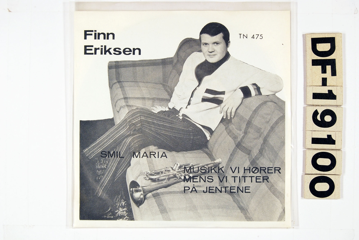 Bilde av Finn Eriksen sittende i en sofa med en trompet ved siden av seg.