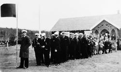 Personer, klær, flagg, forsamlingslokale.