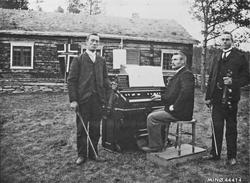 Personer, klær, musikkinstrumenter, bolighus, flagg.