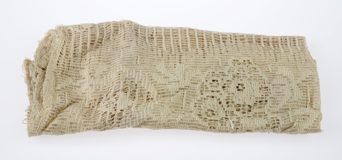 En sjokoladeeske brukt som dukkeseng med dukke, dyne, pute, skinnfell, ullteppe og madrass. Gjenstandene er undernummerert 01-08.
FTT.54432.01: En sjokoladeeske fra Freia brukt som dukkeseng. Esken er med lokk og laget av papp. Den er stiftet i hjørnene. Utenpå er det trykt julenissehoder i rødt og grønt. For tekst se "Påført tekst/merker".
FTT.54432.02: En dukke laget av plast der både armer og bein er bevegelige ved at de er festet med strikk inni dukken. Håret er støpt og er krøllet ved ørene. I ansiktet er det malt øyebryn, øyne, røde kinn og munn. Dukken har på seg en pyjamas laget av flanell. Den er stripete i fargene hvit, blå, lys oransje og grønn. På skjorten er det to knapper i fronten.
FTT.54432.03: En hodepute laget av blått bomullsstoff med heklet trekk. Puten er fyllt med diverse tekstilbiter.
FTT.54432.04: En dyne laget av blått bomullsstoff med en påsydd blondekant foran. Baksiden er sydd sammen av tre ulike tekstiler. Dynen er fyllt med tekstilbiter.
FTT.54432.05: En brunsvart skinnfell, trolig laget av kaninpels.
FTT.54432.06: Et ullteppe som trolig klippet ut av et eksisterende ullteppe. Teppet er gulhvitt med blomster og blader i rosalilla.
FTT.54432.07: Et sammenbrettet stykke som er heklet. Trolig en rest som er brukt som madrass i esken/sengen.
FTT.54432.08: Et sammenbrettet stykke som er heklet. Trolig en rest som er brukt som madrass i esken/sengen.