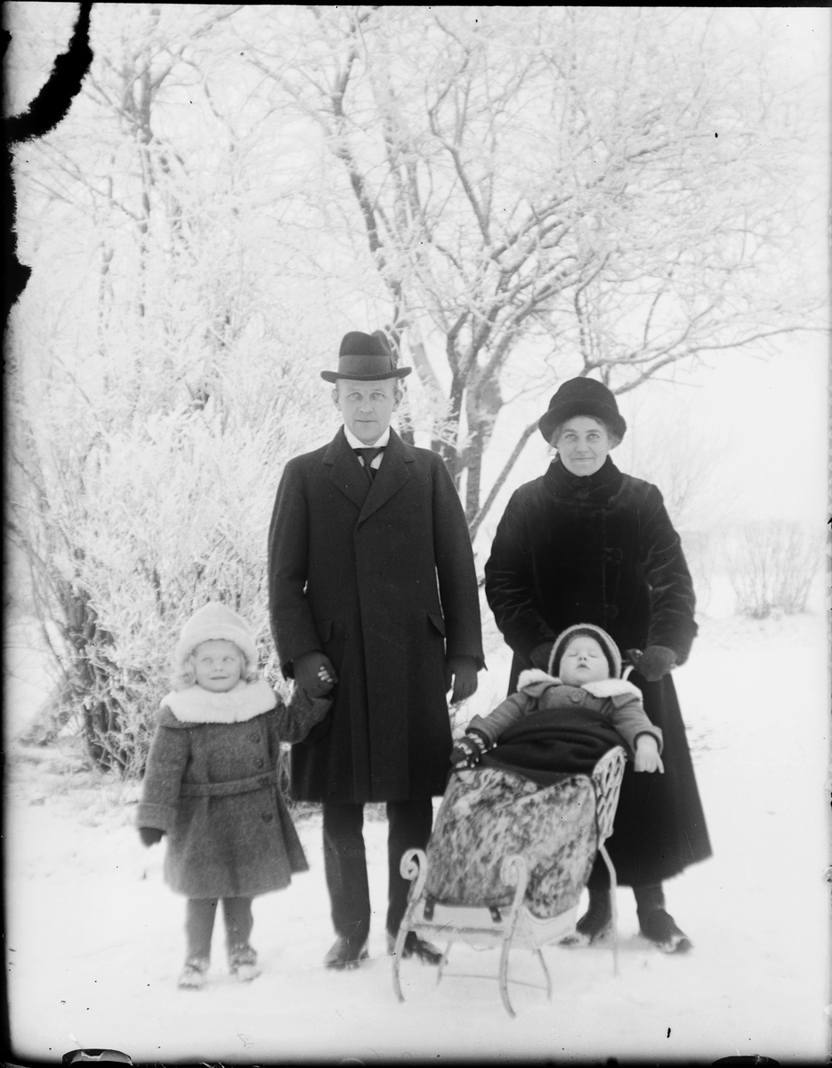 Man och kvinna med två barn, ett barn ligger i en kälke, Östhammar, Uppland