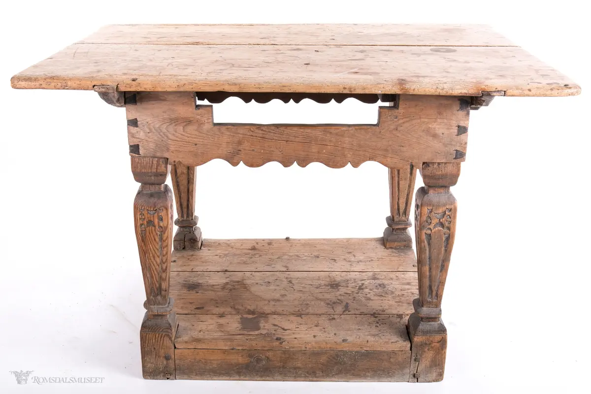 Platen hviler på arkitrav som igjen hviler på koniske pillarer med en form for kannelering med kapitel/terningkapitel og basis. Alt hviler på postamentet med høyde 12 cm.