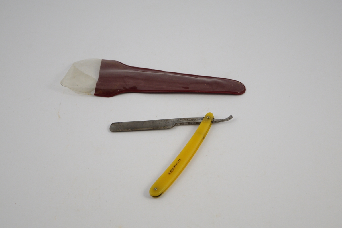 a) Rektangulær kniv, innhukk og smalere flate mot festet. Håndtak: to deler festet m/to skruer, ovale, noe buet form. Kniven kan vris inn mellom disse delene. 
b) Futeral, transparent på den ene side , buet, langstrakt form.