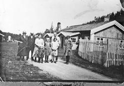 Personer utenfor bygning, stakitt