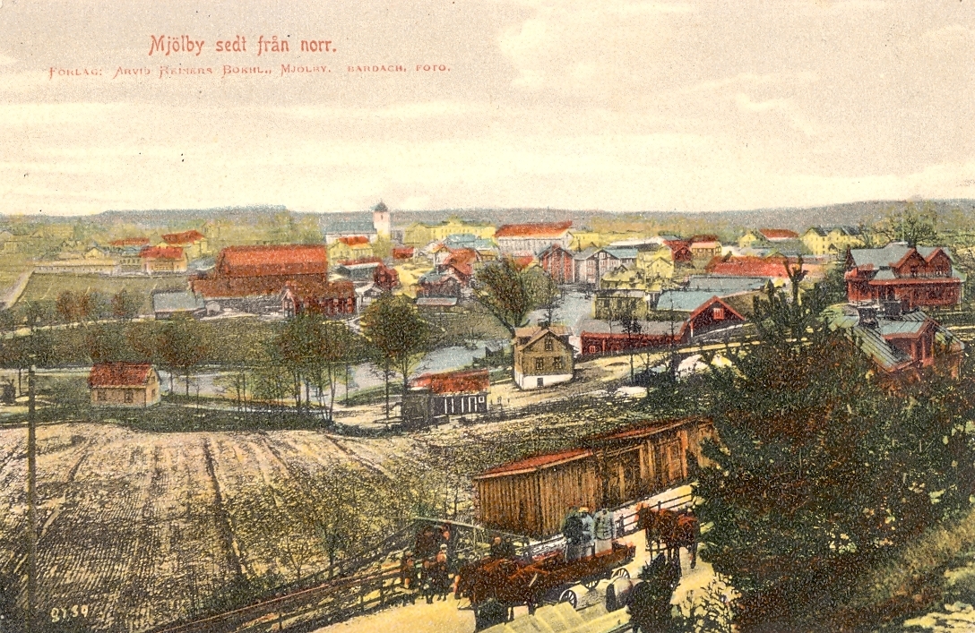 Kolorerat vykort som visar vy över Mjölby sett från norr.