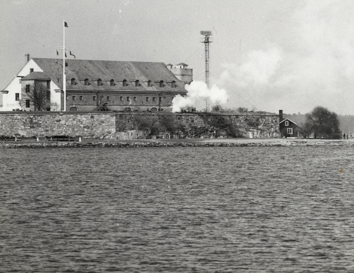 Bilden visar bastion Kungshall med Kungshallsmagasinet på Stumholmen. Framför magasinet syns ett rökmoln.