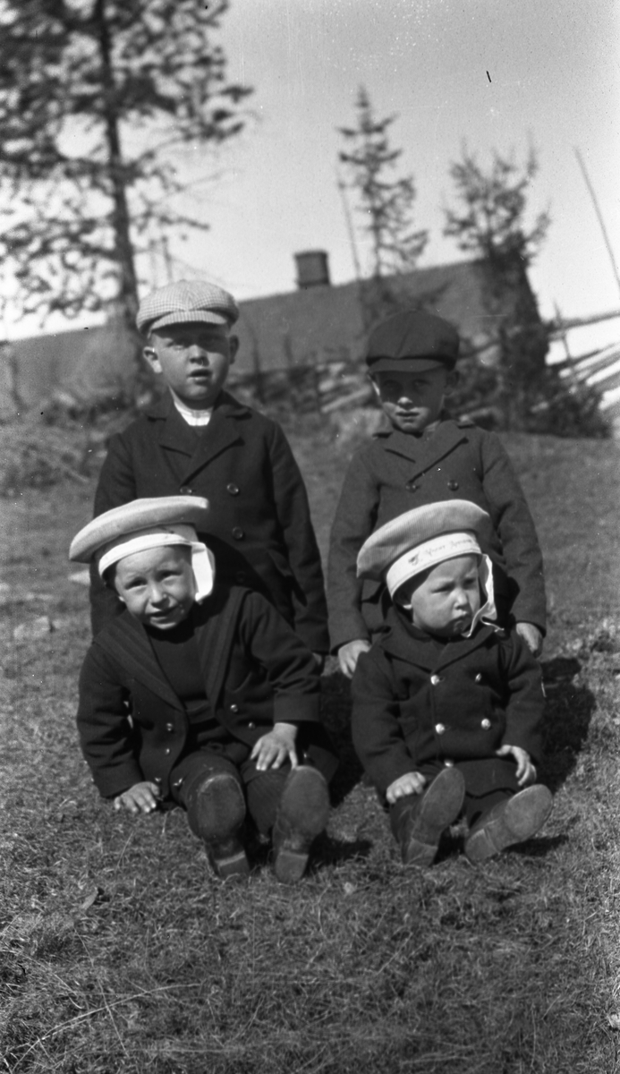 Fire barn som sitter på bakken. De to foran er Kåre (til venstre) og Leif Gunnerød. De to bak Lars Gunnerød (til venstre) og trolig Johan Holmstad.