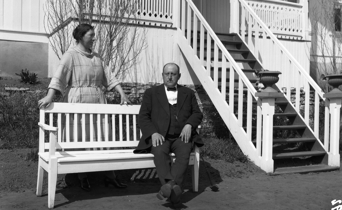 Uidentifisert kvinne og mann foran et våningshus. Fire bilder. På et er kvinnen alene, ellers de to sammen.