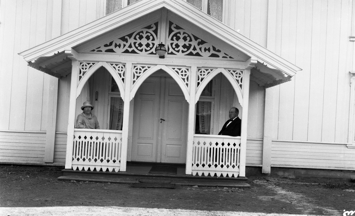 Uidentifisert kvinne og mann foran et våningshus. Fire bilder. På et er kvinnen alene, ellers de to sammen.