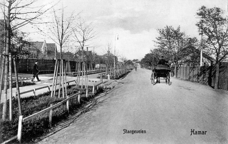 Historisk foto fra Stangevegen i Hamar, med gammel gatebelysning og hest med vogn.