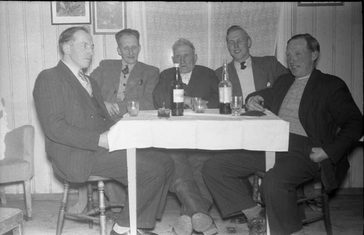 Fem mannspersoner ved et bord, og tydeligvis med noe godt i glassene. Fra venstre: Ukjent, Johan Egge på Gunnerød, Peder Anton Gårderhagen, Johan Johansen, Andreas Johansen. Bildet er fra mars 1949,og trolig tatt i forbindelse med Peder Gårderhagens 75-års jubileum.