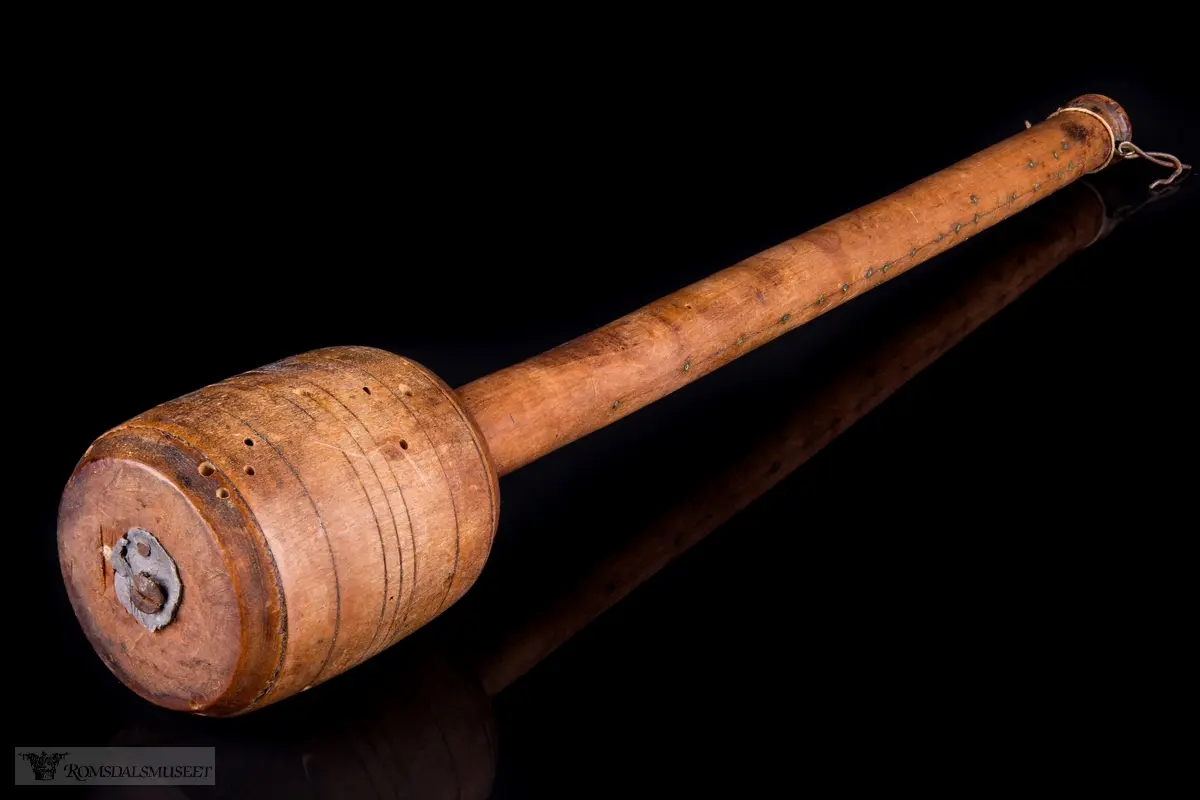 Dreid sylindrisk hode med avrundet skaft og innsatte messingstifter som målemerker.