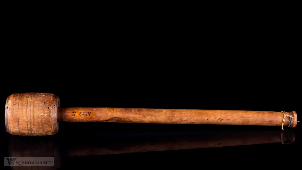 Dreid sylindrisk hode med avrundet skaft og innsatte messingstifter som målemerker.