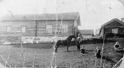 Hest og folk utenfor husene på Åsbakken. Nils Åsen, Lars Jor
