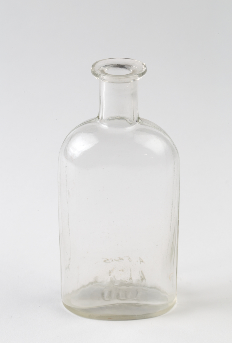Klar glassflaske uten propp. Oval form.