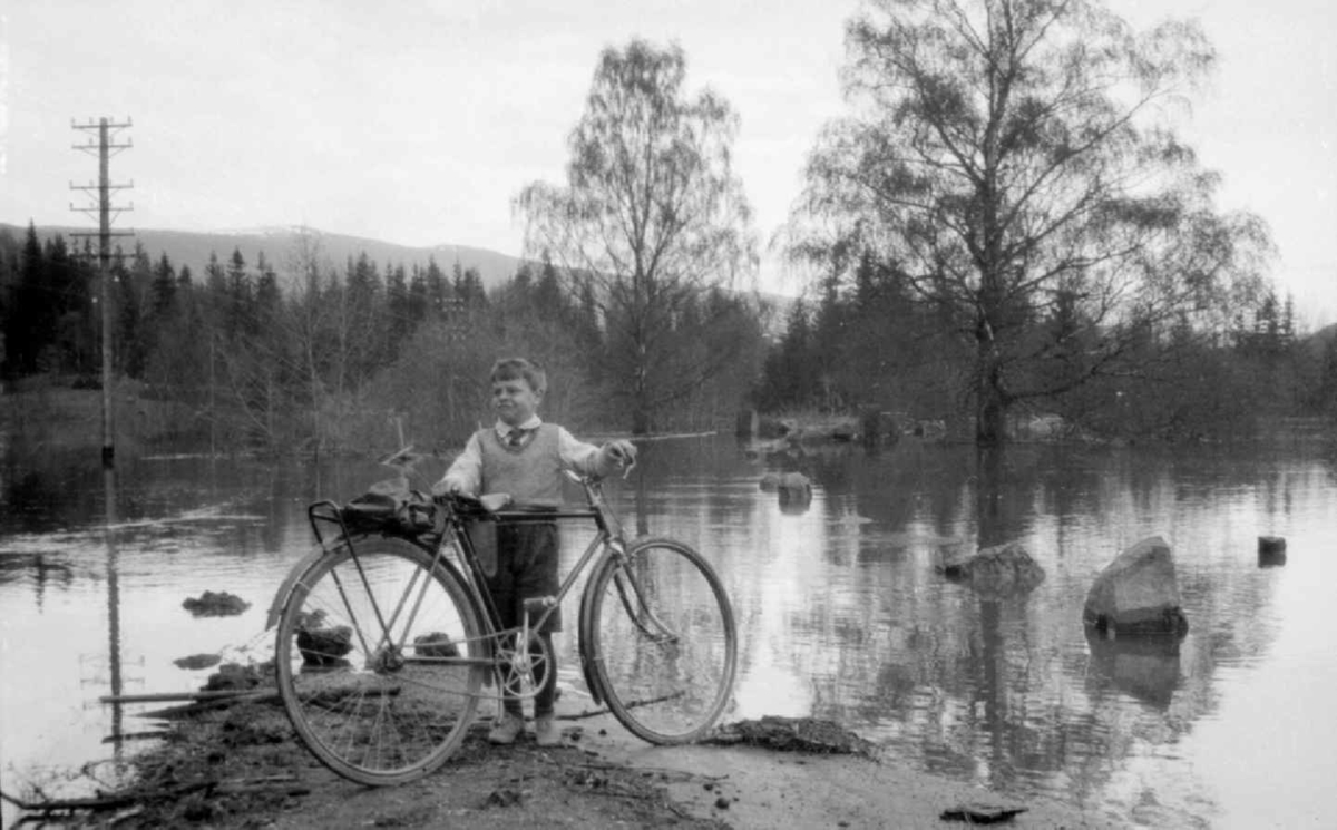 Flom i Gudbrandsdalen i 1934. Gutt med sykkel.
