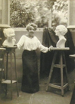 Foto, Agnes de Frumerie mellan två sina skulpturer, inramat.