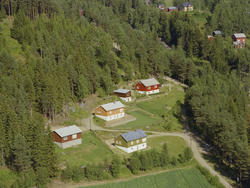 Øyer, Tretten, Bådstulykkja. Fire enetasjes hus med hvitmalt