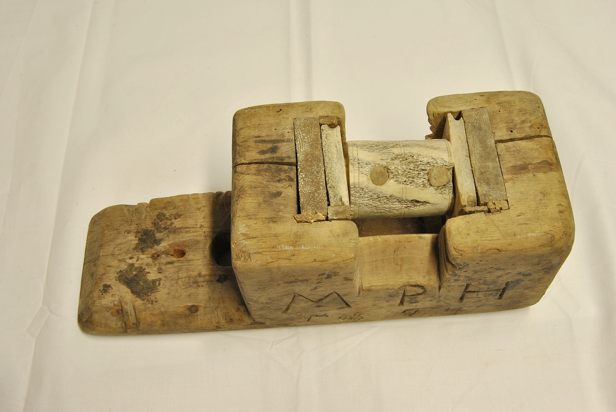 Form: Rektangulær med sirkelforma hjul i midten.