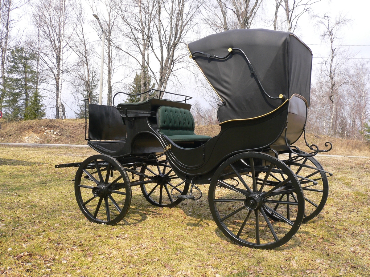 4-hjuls vogn med kalesje for to hester til persontransport. Fast kuskebukk, hovedsete og motsete med lokk. Fast kalesje. To lave dører.