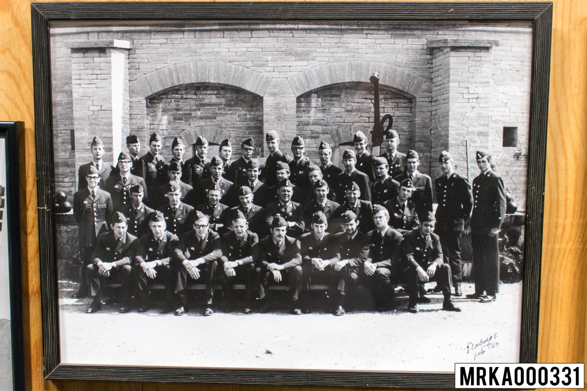 Fotografi taget på befäl och soldater som genomfört grundläggande soldatutbildning på 1:a Batteriet KA 2.
Fotografiet taget på Kungsholmen KA 2.
Flobergs Foto 1969.