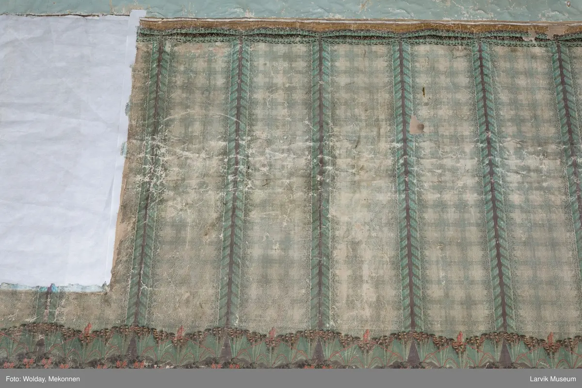 |Tapeten er påmalt tapetborder og brystning. Fra Hovland gård i Larvik.
Den øverste, brede borden: Gerlander/draperi med blomsterranker.
Den nederste, smalere borden: Tekstilbord med blomster. Øver døren til høyre: Stillebenmotiv med blomster og frukt.