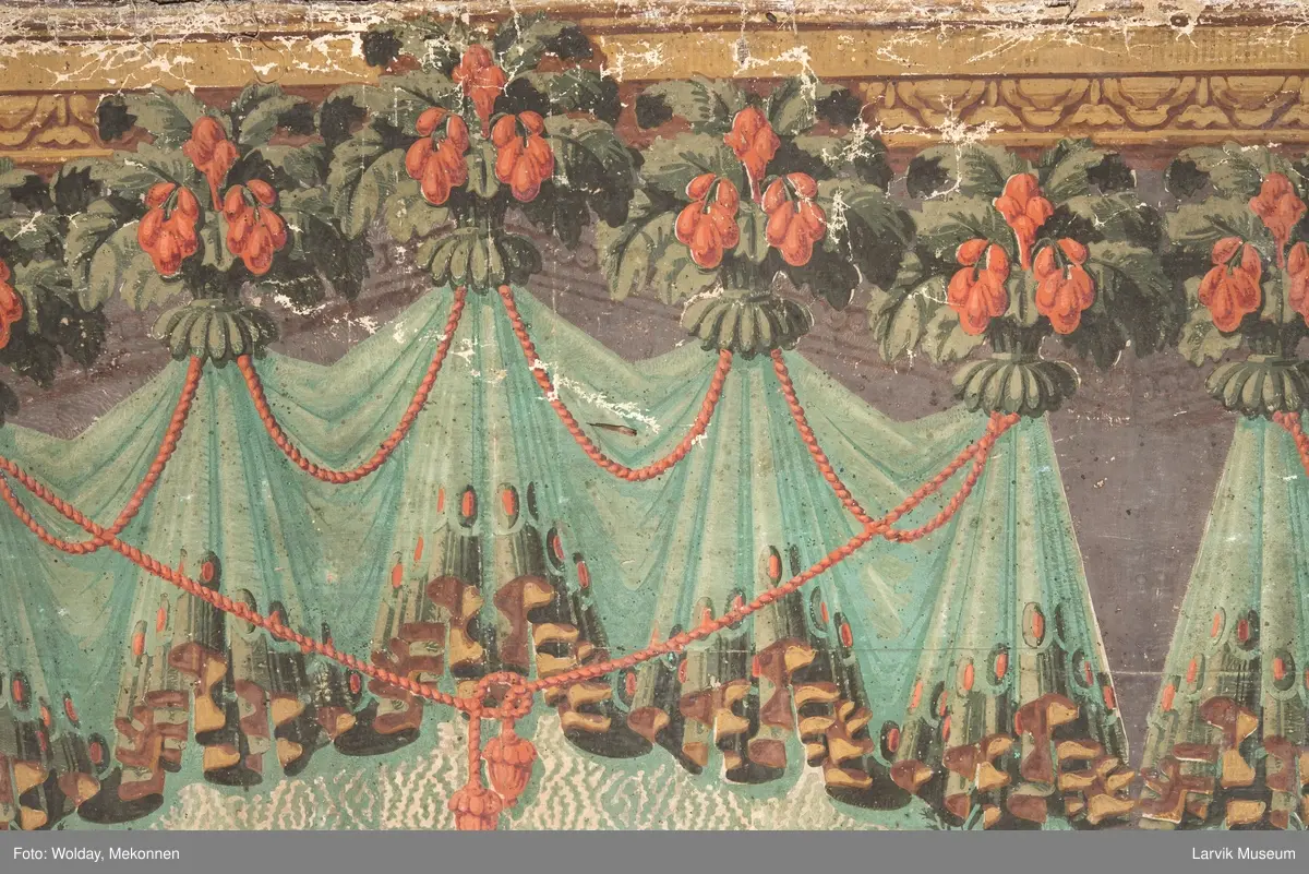 |Tapeten er påmalt tapetborder og brystning. Fra Hovland gård i Larvik.
Den øverste, brede borden: Gerlander/draperi med blomsterranker.
Den nederste, smalere borden: Tekstilbord med blomster. Øver døren til høyre: Stillebenmotiv med blomster og frukt.