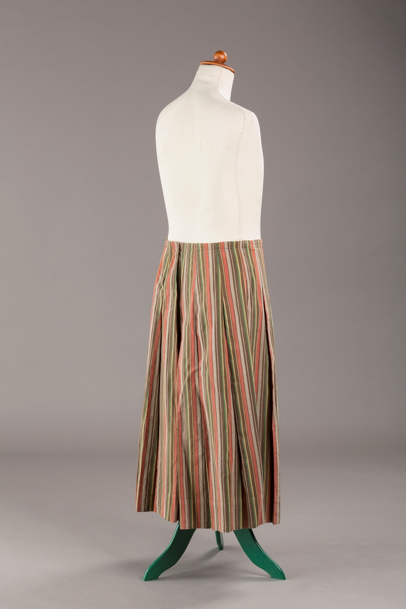 Stripete bomullsskjørt med nedsydde legg, uten linning, lukkes med trykknapper.