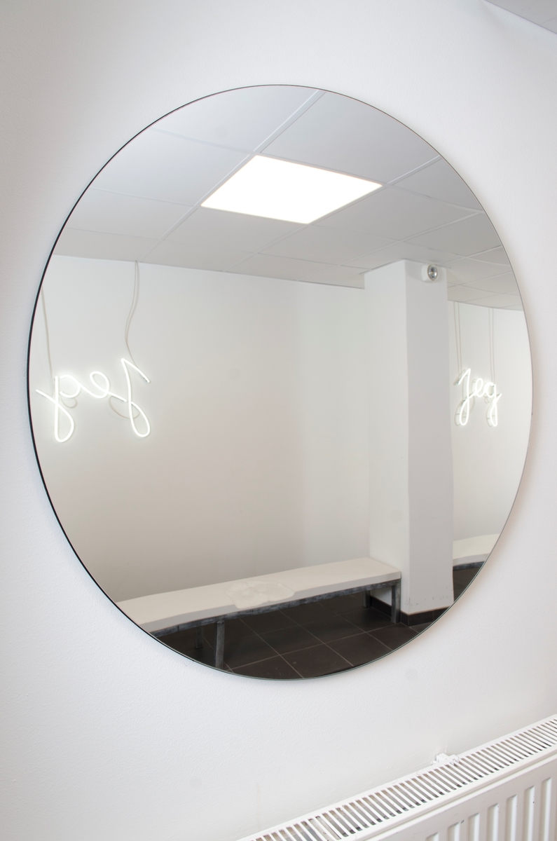 Christensens verk er ein installasjon med to benkar av stål. Benkane er dekt med lys betong kor det er laga avtrykk av menneskekroppar som har sete der. Over kvar benk heng eit kvitt neonrør forma som ordet «jeg». På veggen bak heng det ein rund spegel, slik at begge neonarbeida blir spegla på motståande vegg.

Kunstverket er mogeleg å oppleve også for dei med synshemming, både på grunn av det sterke lyset i neonrøra og fordi det kan utforskast med hendene. Det inviterer til sansing, leik og refleksjon rundt kva det er å vere eit «eg». Spegelen minner om kor viktig spegling i bokstaveleg og overført tyding er for kjensla av kven ein er, og korleis identitet endrar seg over tid. Avtrykka på benkane er i ulik storleik, så ein kan setje seg i dei og kjenne etter om ein passar inn – eller berre sjå på kunsten på motsett side.