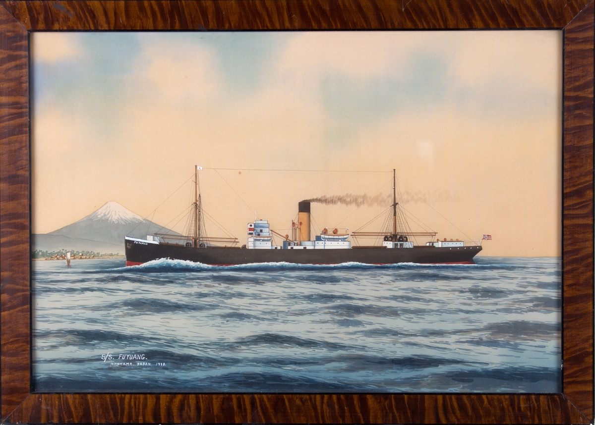 Skipsportrett av DS FU YUANG med Fuji-fjellet og Yokohama i bakgrunnen. Skipet fører japansk flagg i formast og norsk flagg akter. Ser et mindre seilfartøy foran skipets baug.
