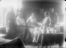 3 menn i uniform og 3 kvinner (1 i sykepleiedrakt) ved kaffe