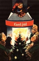 Julekort. Ubrukt. Interiør. Menn og kvinner foran peisen.
N