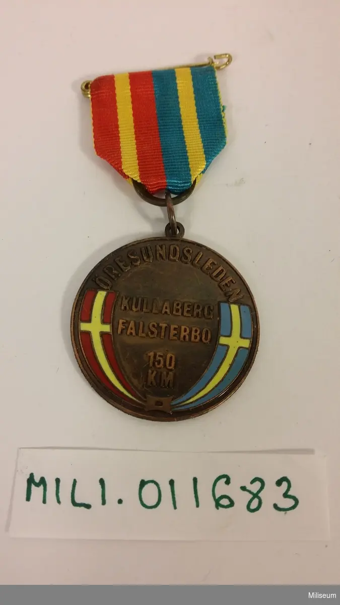 Medalj i valören brons (brons med emalj).