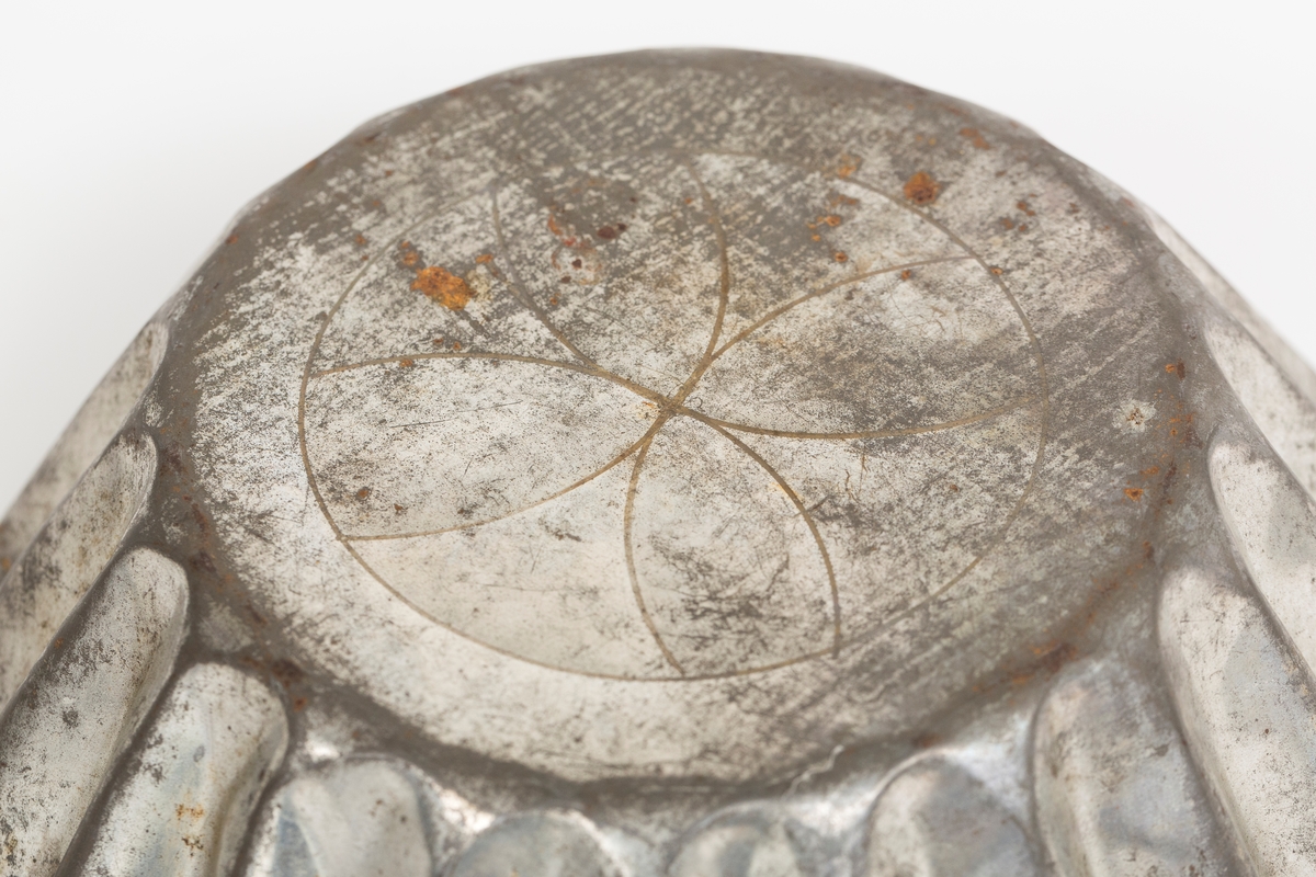 Kakeform for terte, også kalt terteform. Blomstdekor på bunnen av formen. Noe rust på formen.