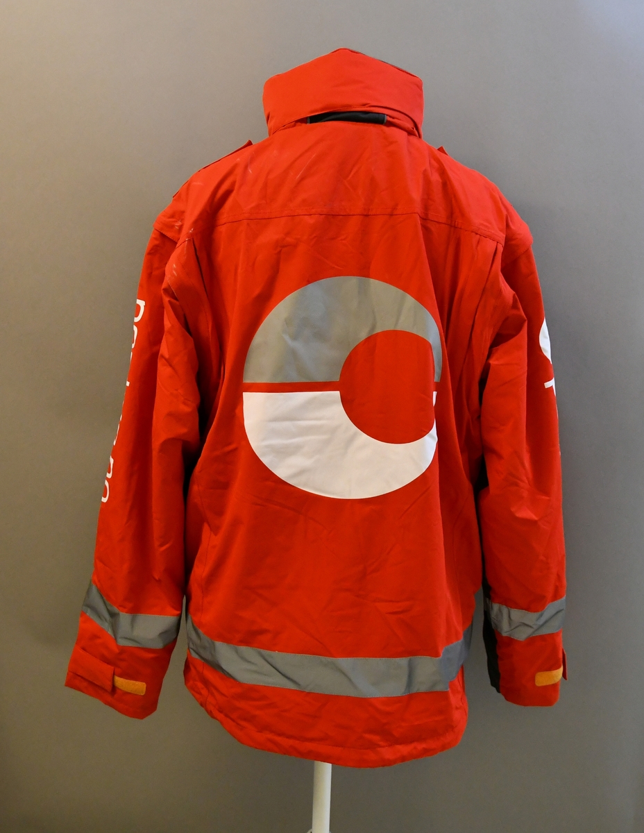 Rød uniformsjakke med tekst og posthornemblem. Med hette og avtagbart for. Med 4 lommer og mobillomme. Refleksbånd i livet og på ermene.

Størrelse XL