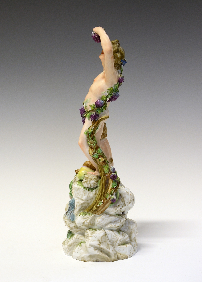 Dionysos kryster druer, og spiser fra en drueklase, Pan sittende ved hans føtter, begge på en immitert bergsokkel.