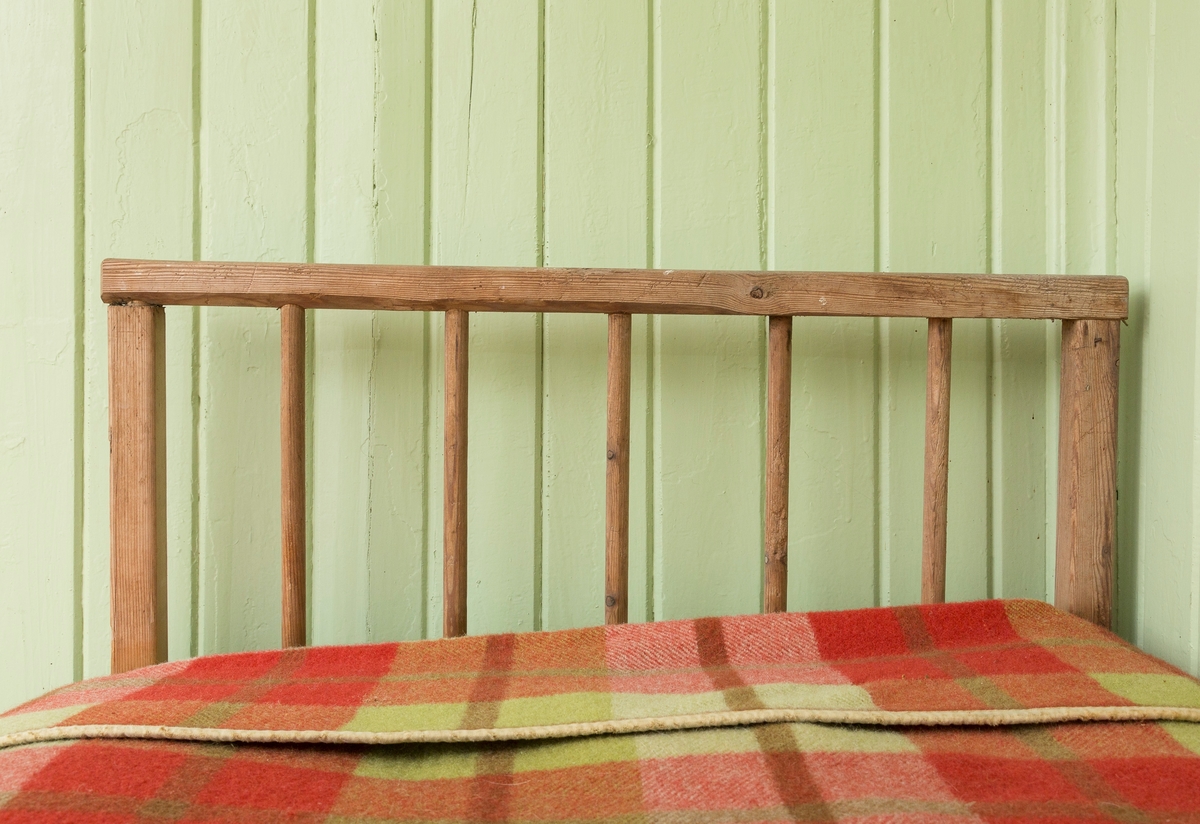 Sengeramme med sangegavler bestående av staver. Ubehandlet tre. Avstivere i metall. Nettingbunn.