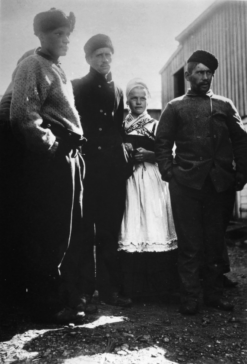 Russiske fiskere i Kiberg 1899. På bildet står en nordmann til venstre og to russiske menn med ei russisk jente. De lytter til et omreisende musikkselskap, skriver Ellisif Wessel på baksiden av originalbildet.