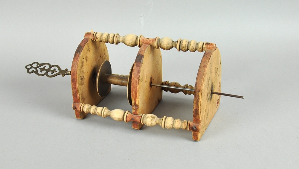 Snellestol med plass til to sneller. Tre hyller er festet sammen med tre dreide stolper, snellene festes på en metallstang som går gjennom hyllene. Hyllene er avrundet foran og rett bak. Snellestolen kan festes på veggen.