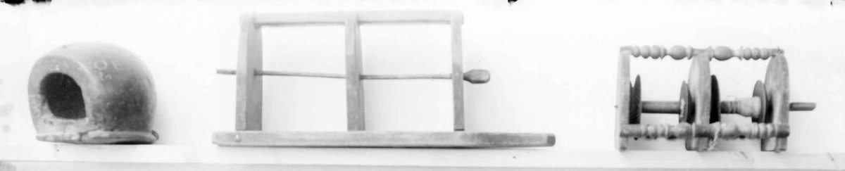 Snellestol av tre med plass til to sneller. Det er festet tre hyller på en treplate. Snellene festes på en metallstang som er går gjennom hyllene. Hyllene er avrundtet foran, og snellestolen kan festes på veggen.