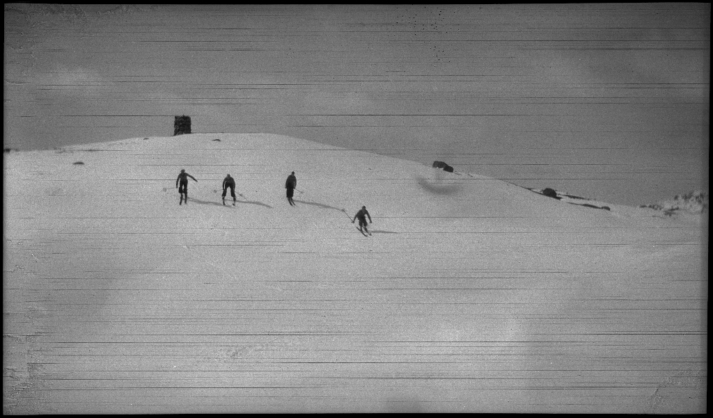 Fire unge menn på skitur påsken 1936. De har laget en bil av snø med bobleform (kanskje inspirert av Porsche Typ 1 fra 1935). Det er også bilder fra flere fjelltopper, fra skigåing og fra ei turisthytte.