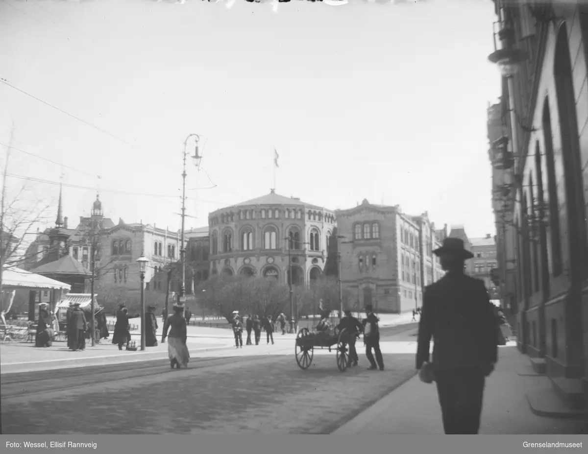 Stortinget Oslo, ca 1900. Folkeliv på gaten, en mann med kjerre.