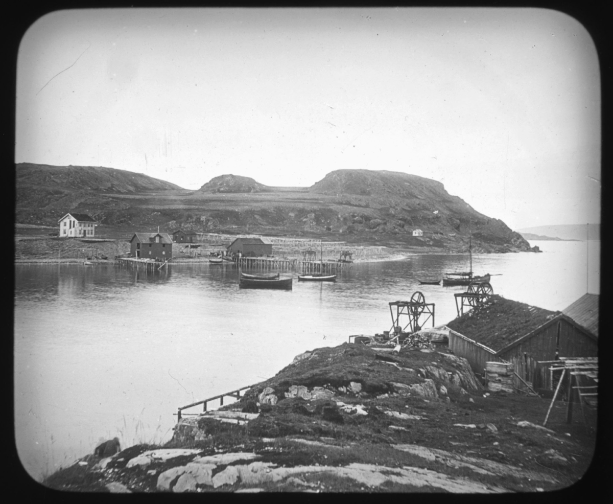 "Serie 109. No. 23. Det Nordlige Norge" står det på glassnegativet. Bildet viser et fiskevær med kai, båter og fiskebruk, vinsjer og et hvitt bolighus helt til høyre i bildet. Det er også et tørkestativ for garn eller fisk til venstre i blidet og det ligger garn på bakken. Bildeserien av Hanna Resvoll-Holmsen er fra Nordland, Troms og Finnmark. Vi vet også at hun tilbrakte endel tid i Lebesby, Finnmark, i 1909. Fotoserien  er sannsynligvis tatt på reisen nordover og i Øst-Finnmark. Botaniker Hanna Resvoll Holmsen fikk et reisestipend fra Universitetet i Oslo for å kartlegge arktisk vegetasjon i 1909. To foredrag om en ekspedisjon til Svalbard i 1907 ga grunnlag for et reisestipendet fra Oslo Universitet til Øst-Finnmark i 1909. Hanna Resvoll-Holmsens Svalbardekspedisjon kom i stand med støtte fra fyrsten av Monaco, som ville gi ut en bok om Svalbard. Hanna  gikk alene i land på Svalbard i juli 1907 og tilbrakte en måned i telt, med gevær og utstyr for innsamling og preservering av planter. Studiene på Svalbard ble senere publisert med overskriften "Observations botaniques" og utgitt i Monaco.  Hanna Resvoll Holmsen regnes også som pioner innen fargefotografi, de tidligste fra før 1910, blant annet fra Svalbard.
