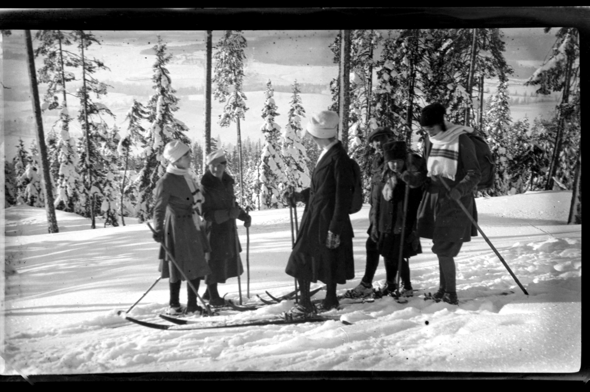 Voksne og barn på ski, antagelig i Voksenkollen, Oslo. Fra venstre Hilda Sundt, Sigrid Jersin, ukjent, Louis Jersin med datter Esther samt Birgit Aubert. Fotografert ca. 1920.