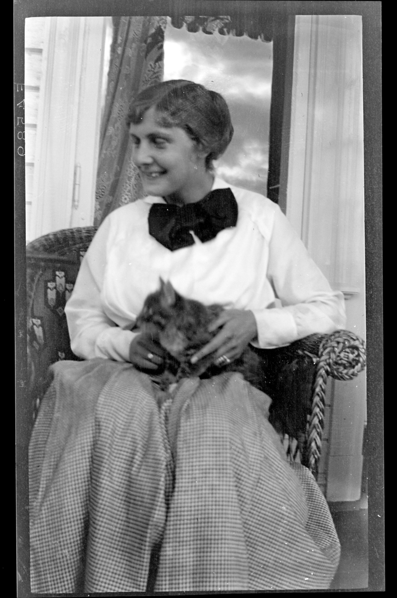 Hilda Sundt sitter i en stol med en katt på fanget. Fotografert 1915-1917.