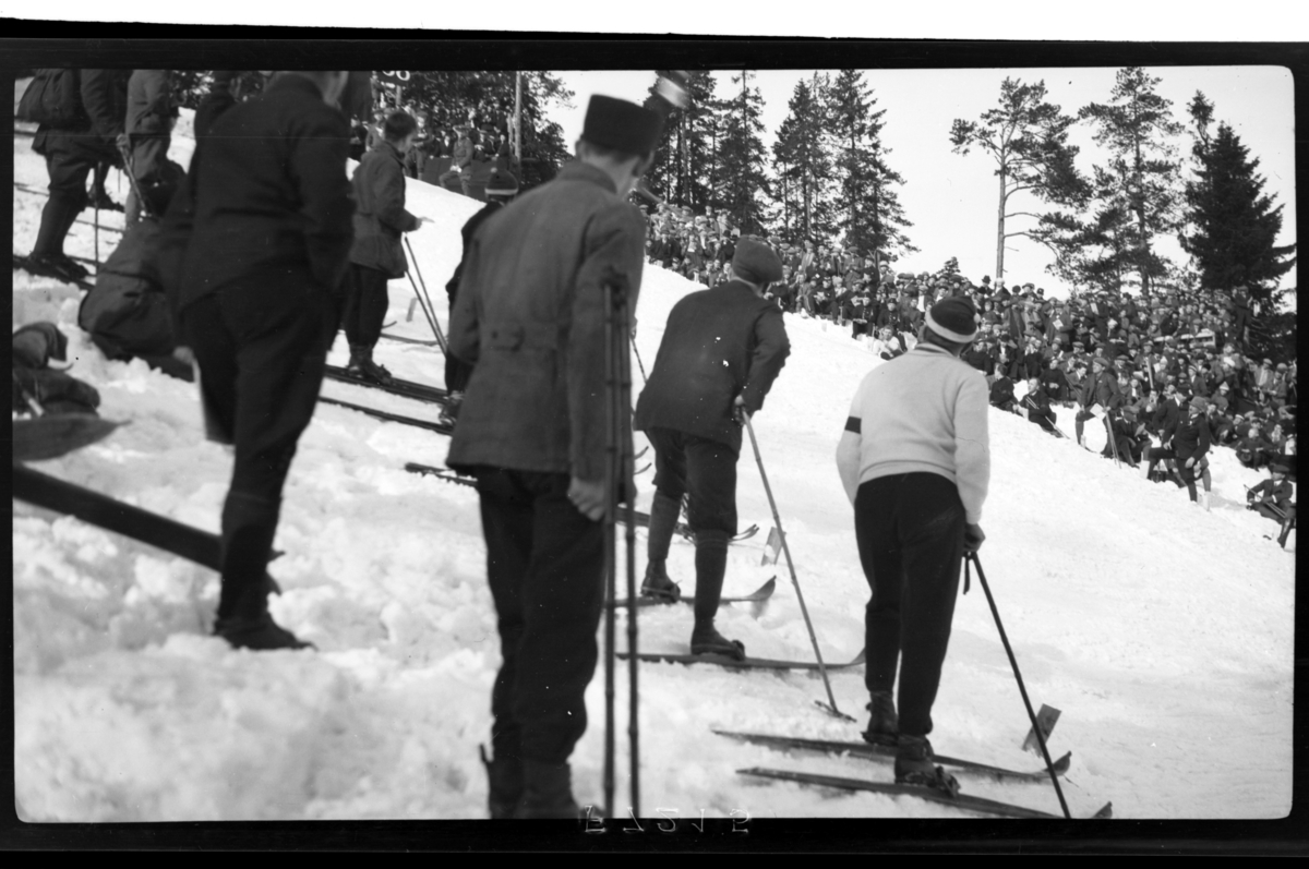 Mange ukjente tilskuere står ved hoppbakken i Holmenkollen. Fotografert 1918-1919.