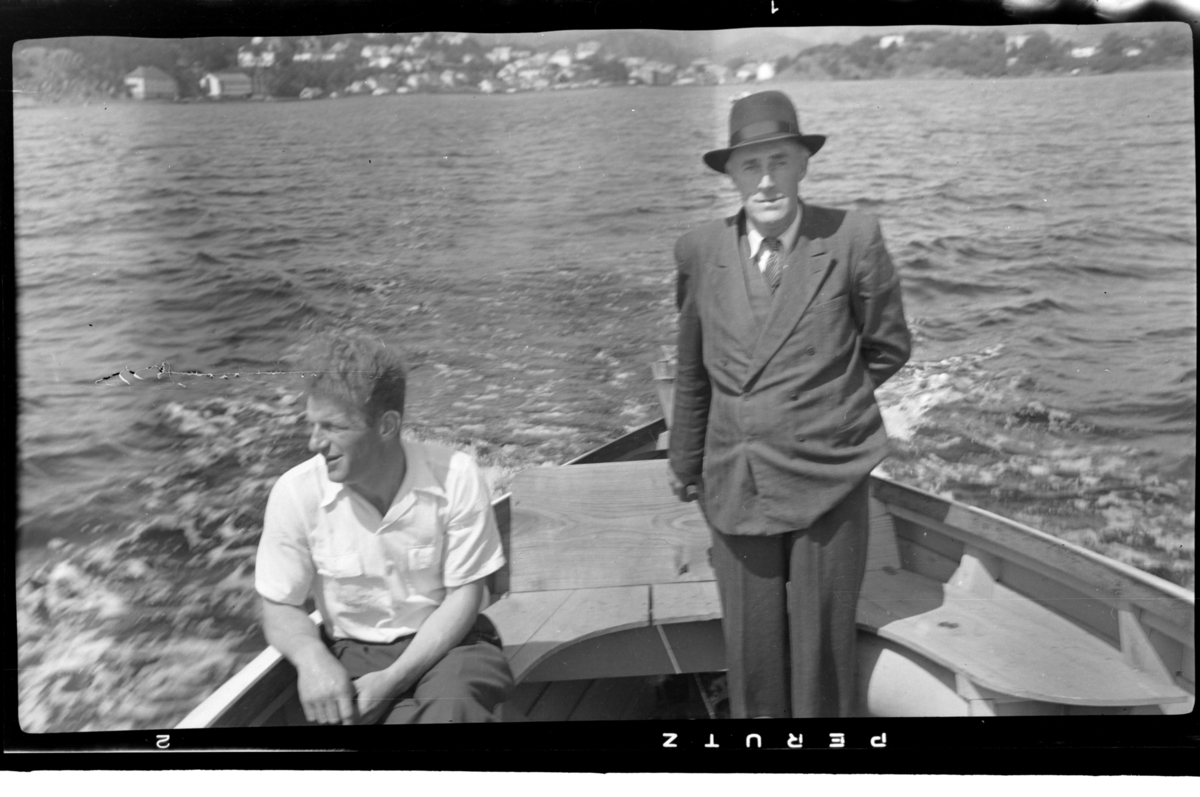 Ole Olsen og Leonard Olsen ombord i en motorbåt på vei ut fra Farsund. Fotografert mai 1952.