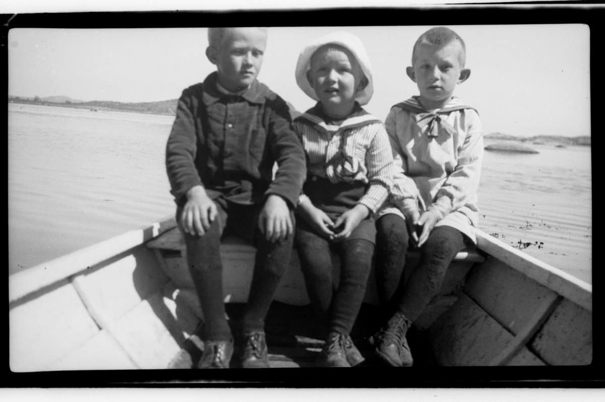 Fetterne Bjarne Halfdannsønn Sundt og Julius Sundt  sitter i en robåt sammen med en ukjent gutt, Stavern. Fotografert 1920.